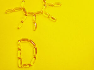 An image of a sun and the letter d created with vitamin d capsules.